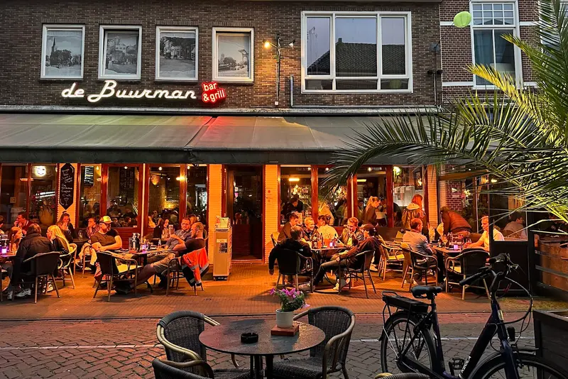 Gevel van De Buurman met terras in de avondzon